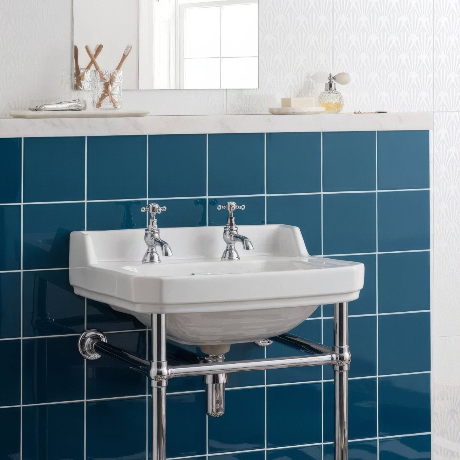 White ceramic pedestal sink with chrome faucets and plumbing paired with baroque blue field tile wall