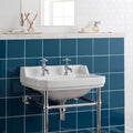 White ceramic pedestal sink with chrome faucets and plumbing paired with baroque blue field tile wall