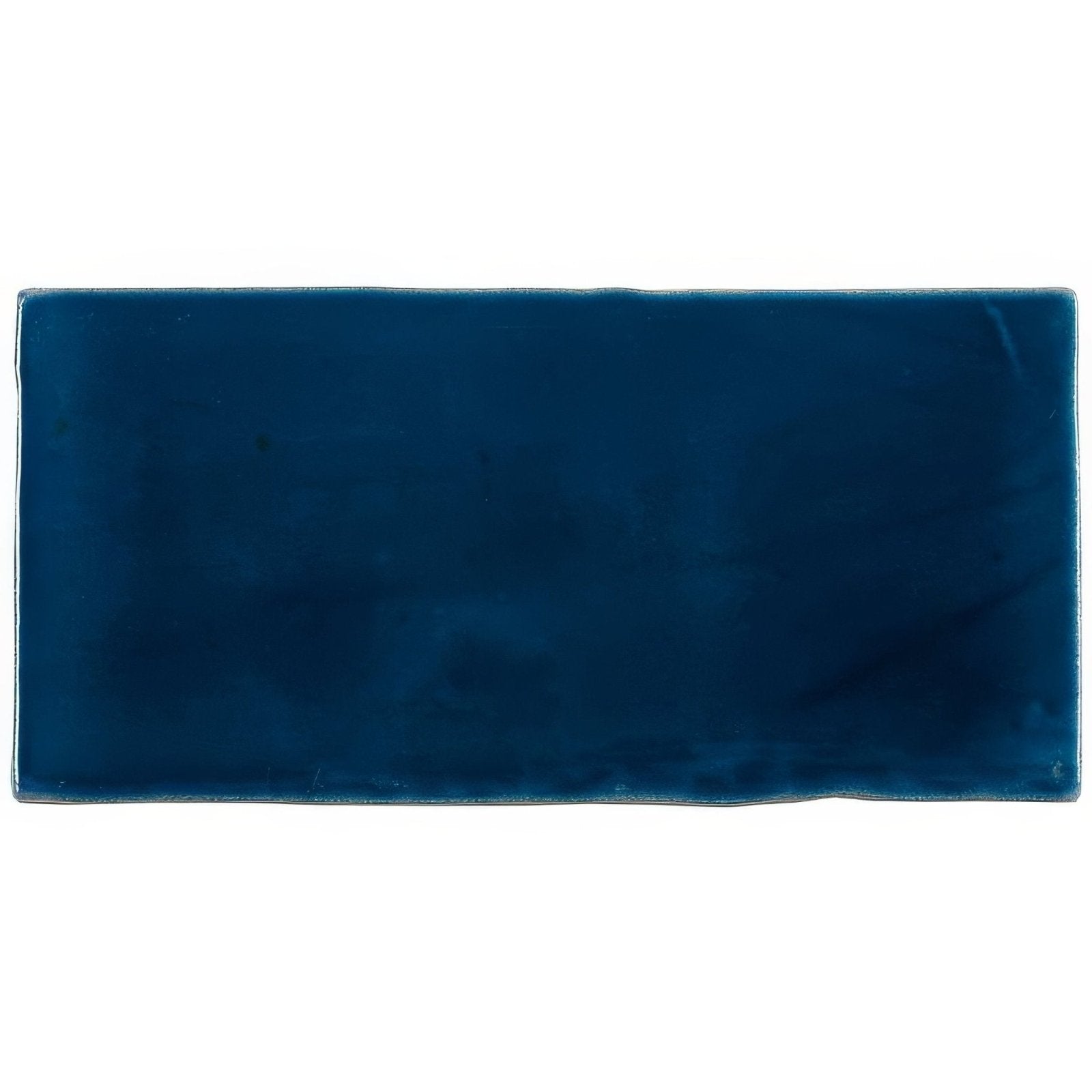 A rectangular deep navy blue ceramic bastille half tile wall tile with a smooth glossy finish