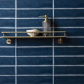 Brass double-tiered bathroom shelf with sleek minimalist design featured on bastille large brick tile background