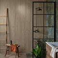 A modern shower enclosure with black metal framing and glass panels set against textured wooden wall tiles in beach hut fluted porcelain caramel
