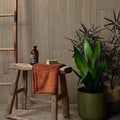 Rust-colored beach hut fluted porcelain caramel towel with textured looped edge draped over rustic wooden stool