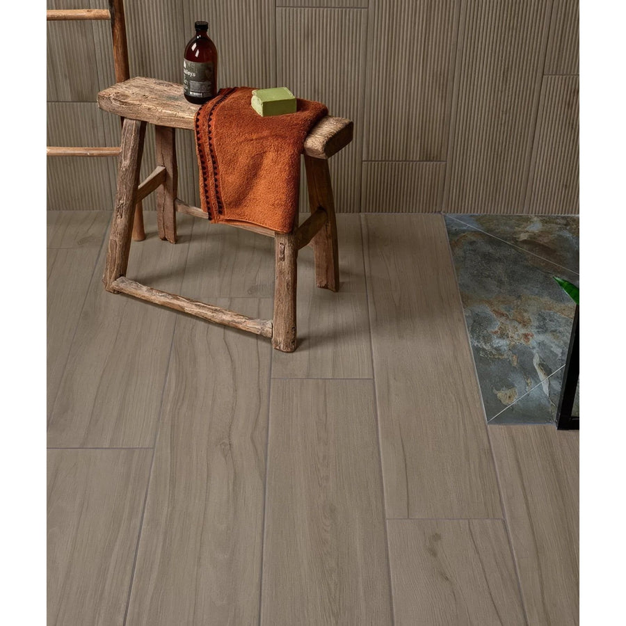 Rustic wooden stool with rough hewn legs and weathered surface topped by orange towel in Beach Hut Porcelain Caramel style
