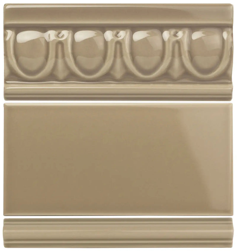 Beige ceramic tile set featuring a decorative molded border with repeating oval and leaf motifs above a plain rectangular panel.
