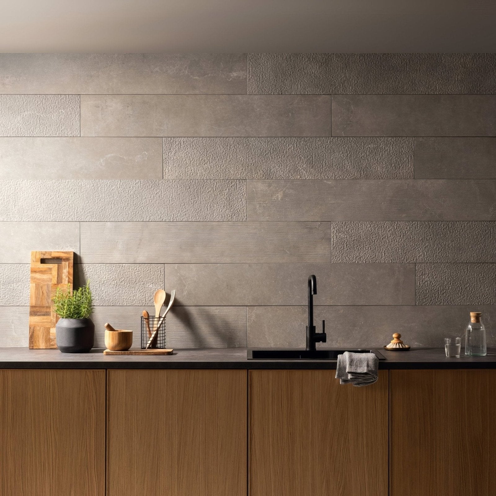Gray textured concrete wall tiles arranged horizontally from the berliner zement line collection