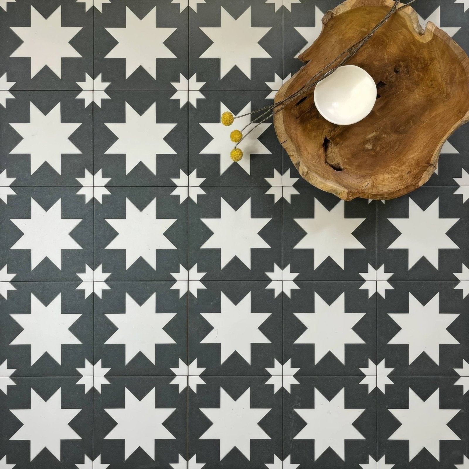 White ceramic bowl resting on rustic wooden slab in Bert & May black pradena porcelain collection