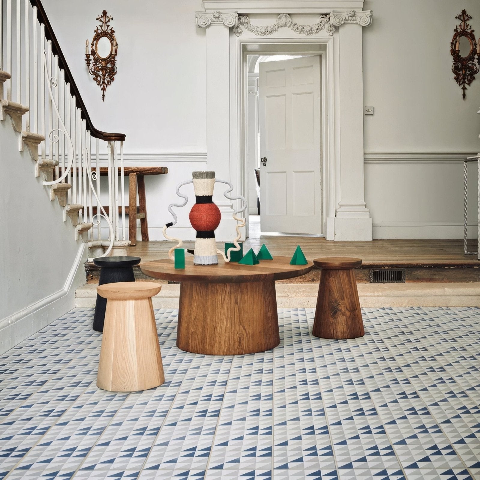 A sculptural abstract centerpiece with a red spherical base and white curved porcelain elements by Bert and May