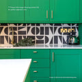 Green kitchen cabinet with gold handles and geometric black and white backsplash in bert and may split shift old iron porcelain