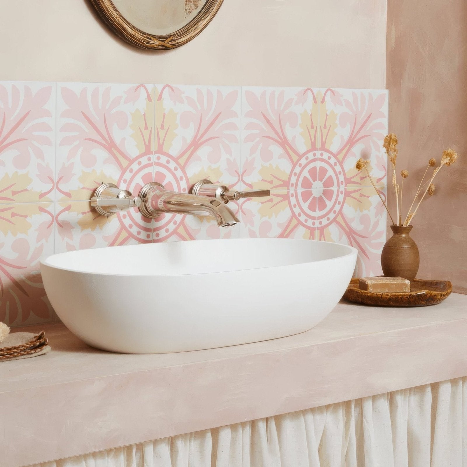 White oval Bert & May Turenne porcelain sink with polished chrome faucet on pink and cream patterned tile backsplash