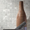 Bianco 25mm Square white shimmering mosaic styled with a tall wooden bottle