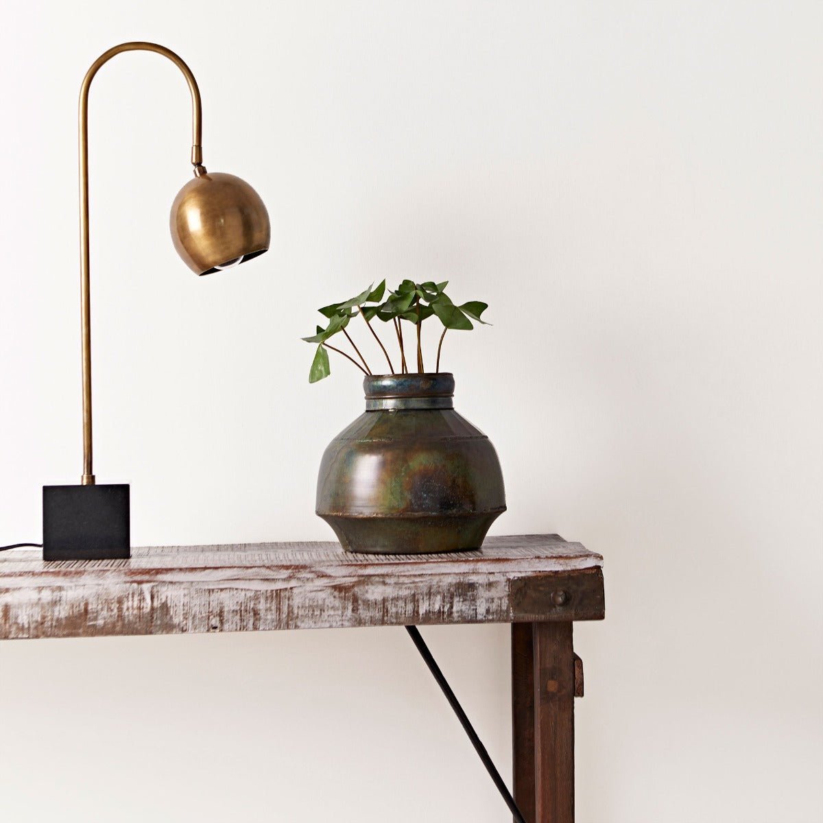 Fired Earth Bianco Paint off-white painted wall with a bronze vase of greenery