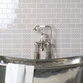 A bicton on dunwich vintage-style chrome bathtub with a polished reflective surface and white towels draped over the edge