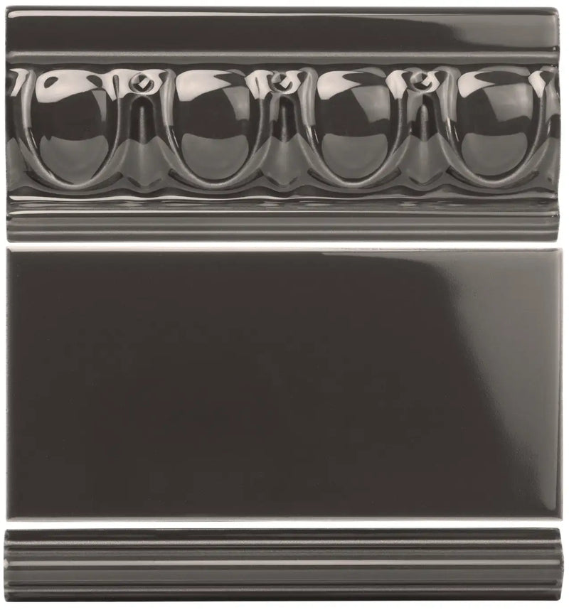 Black glossy ceramic tile with a decorative beaded border design.