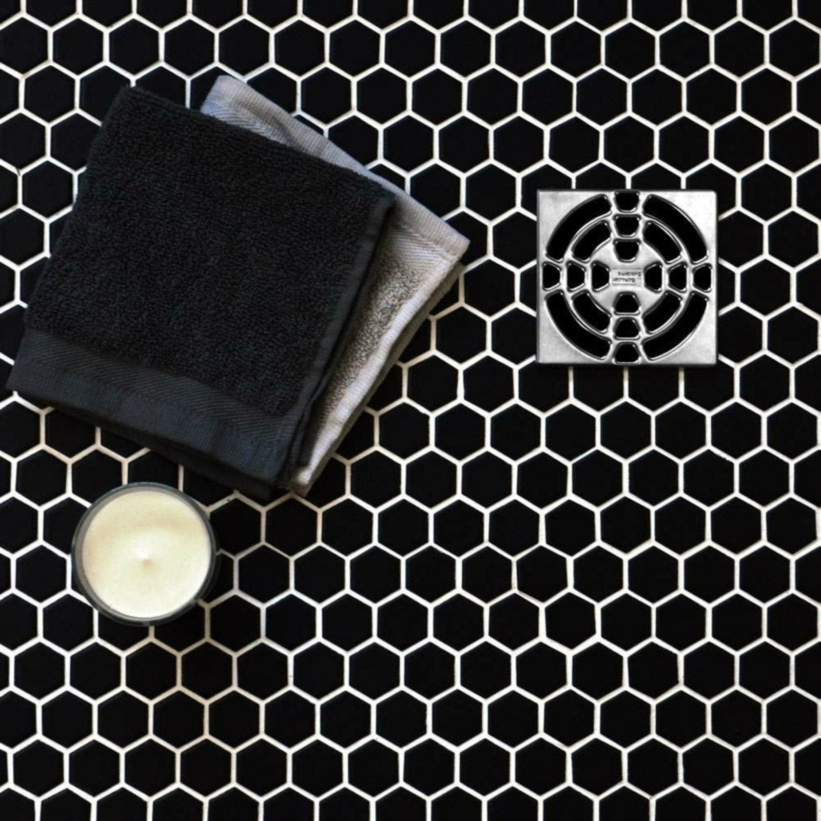 Silver square shower drain with geometric cutout pattern for black honeycomb floor mosaic design
