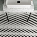 Black & White Honeycomb Floor Mosaic black and white hexagonal mosaic flooring with a white vessel sink on a marble countertop