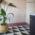 Blends Carrara Triangle white Carrara marble triangle tiles with a tall potted plant
