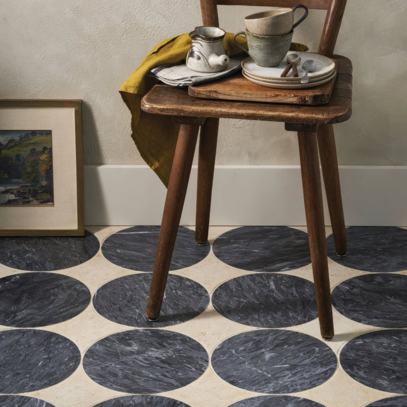 Blends Nero Circle dark grey marble circle tiles with a rustic wooden chair