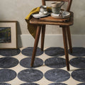 Blends Nero Circle dark grey marble circle tiles with a rustic wooden chair