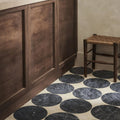 Blends tarla star dark gray circular marble tiles with subtle veining arranged on off-white floor