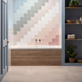 A modern bathroom bathtub with a blossom field tile mosaic backsplash in soft pastel pink gray and white tones