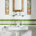 White ceramic pedestal sink with chrome faucets featuring blue iris border on brilliant white detail