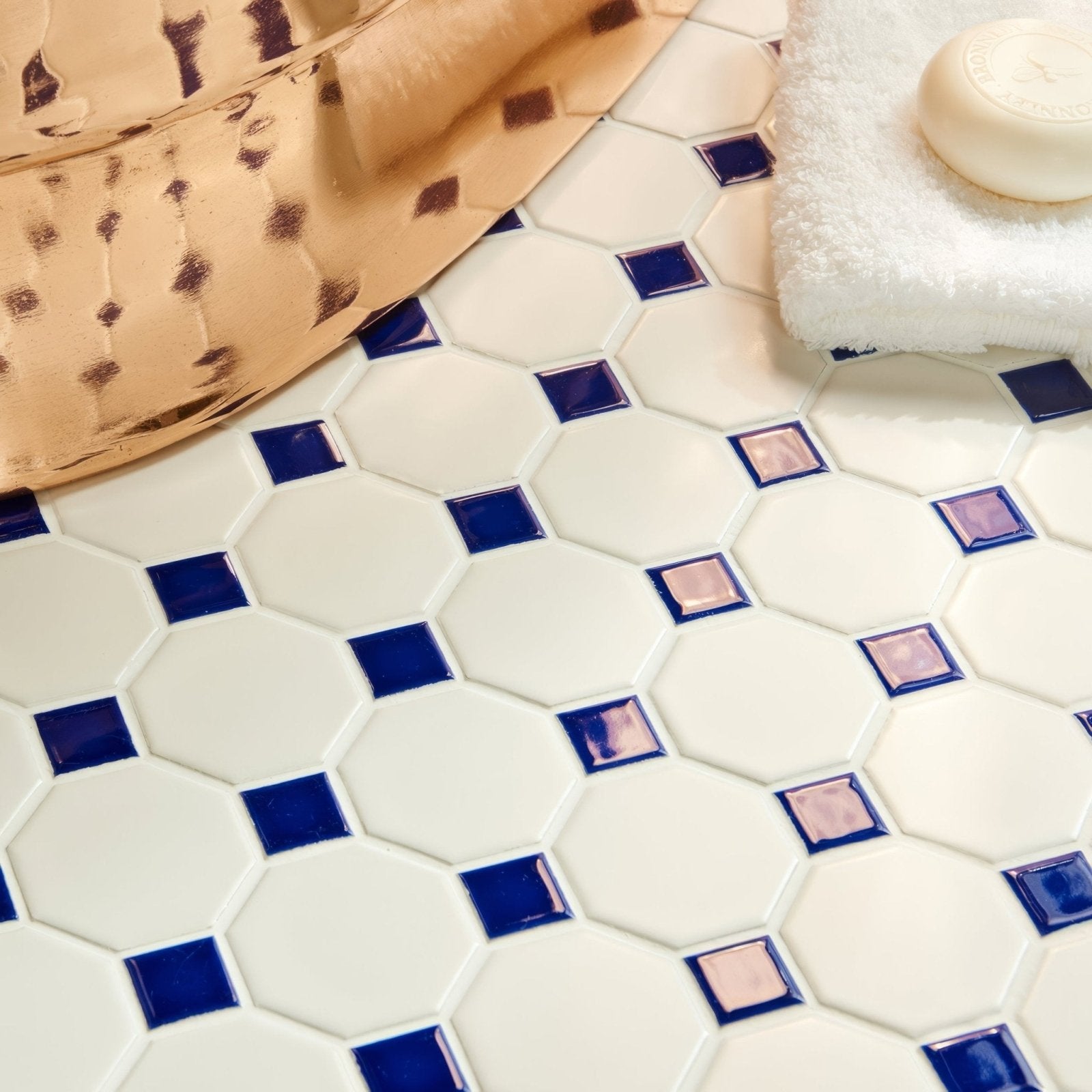 White hexagonal mosaic tile floor with navy blue and rose gold accent squares in blue octagon and dot floor mosaic