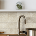 Bottocino Tumbled Marble 150 x 75mm cream tumbled marble tiles behind a brushed stainless steel kitchen tap