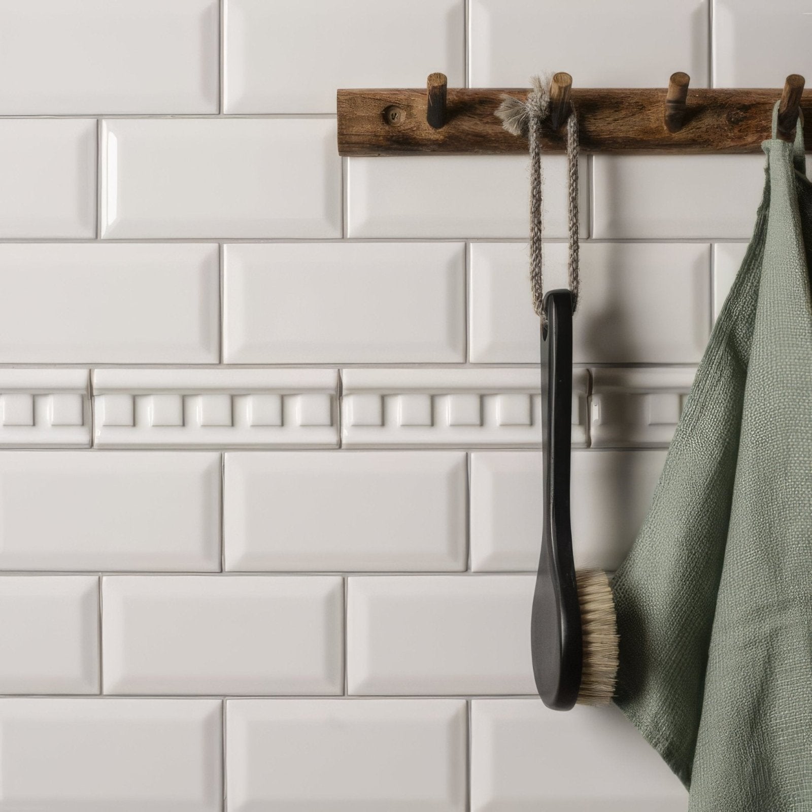 Brilliant white dentil moulding with black-handled bath brush with natural bristles hanging on wooden rack
