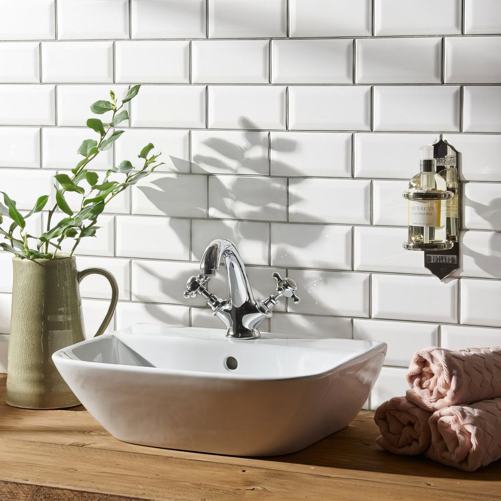 Chrome finished two-handle faucet with modern design on white ceramic vessel sink in brilliant white metro bevelled tile setting