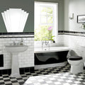 Black and white freestanding bathtub with chrome fixtures next to brilliant white metro bevelled tile wall