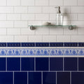 Brilliant white omega moulding featuring decorative blue and white ceramic tile border with intricate leaf patterns