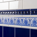 Blue and white ceramic tile border with ornate foliate patterns for brilliant white omega moulding trim
