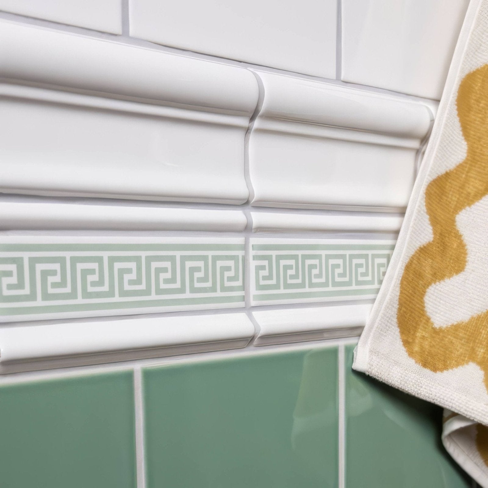 Brilliant white victoria moulding white ceramic tile trim with light gray greek key pattern between white and mint tiles
