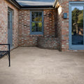 Beige stone patio tiles with subtle texture and light grout lines in brit stone pennant porcelain paving