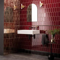 White rectangular wall-mounted sink with black metal brackets and faucet featured in burgundy half tile setting