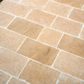 Beige rectangular buscot limestone cobble pavers with tumbled and etched finish and light-colored grout lines