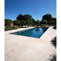 Rectangular buscot limestone paving with etched finish in light beige surrounding clear blue pool water