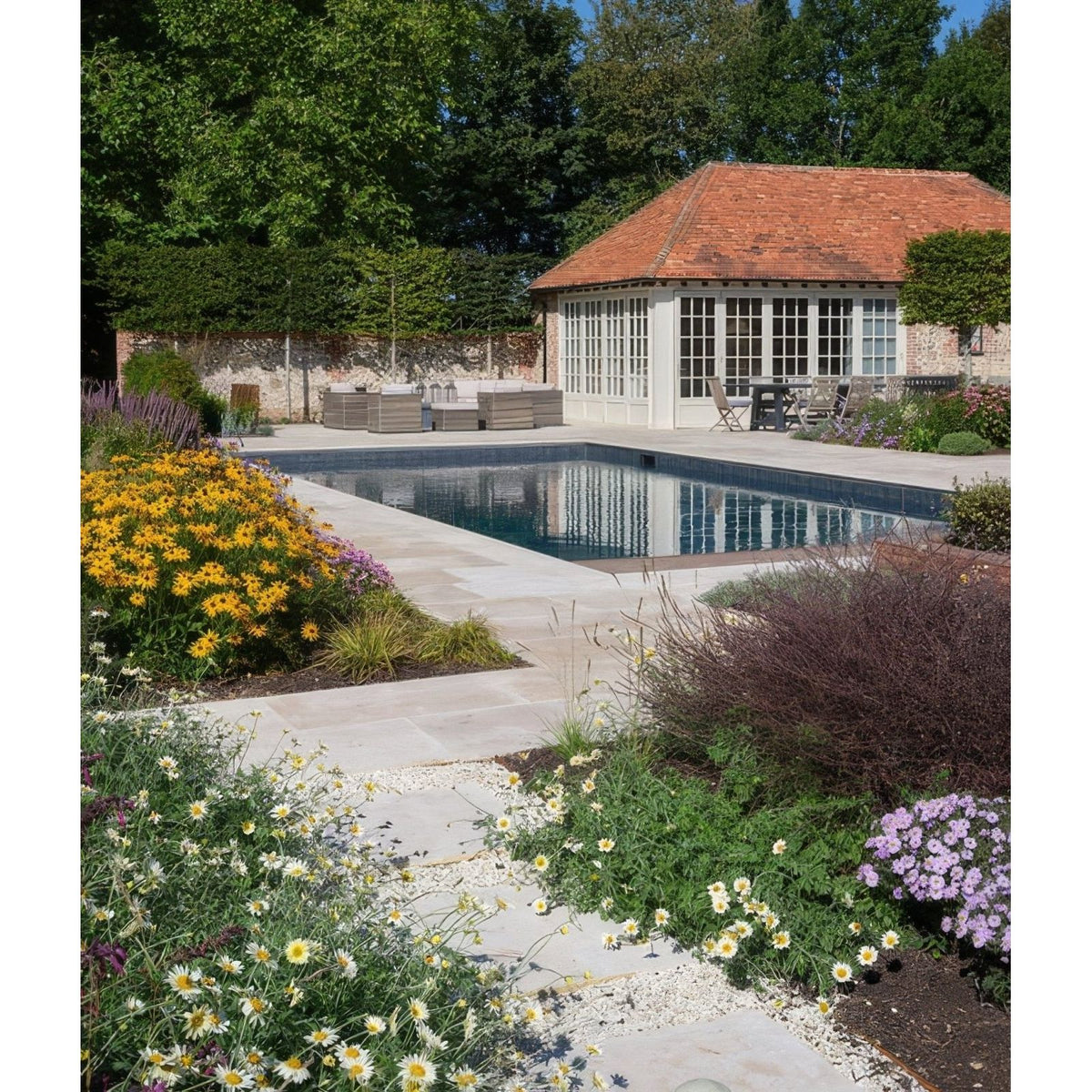 Rectangular buscot limestone paving with etched finish in calm blue reflecting surrounding greenery and sky