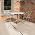 White wrought iron table on Buscot Limestone Tumbled & Etched floor tiles