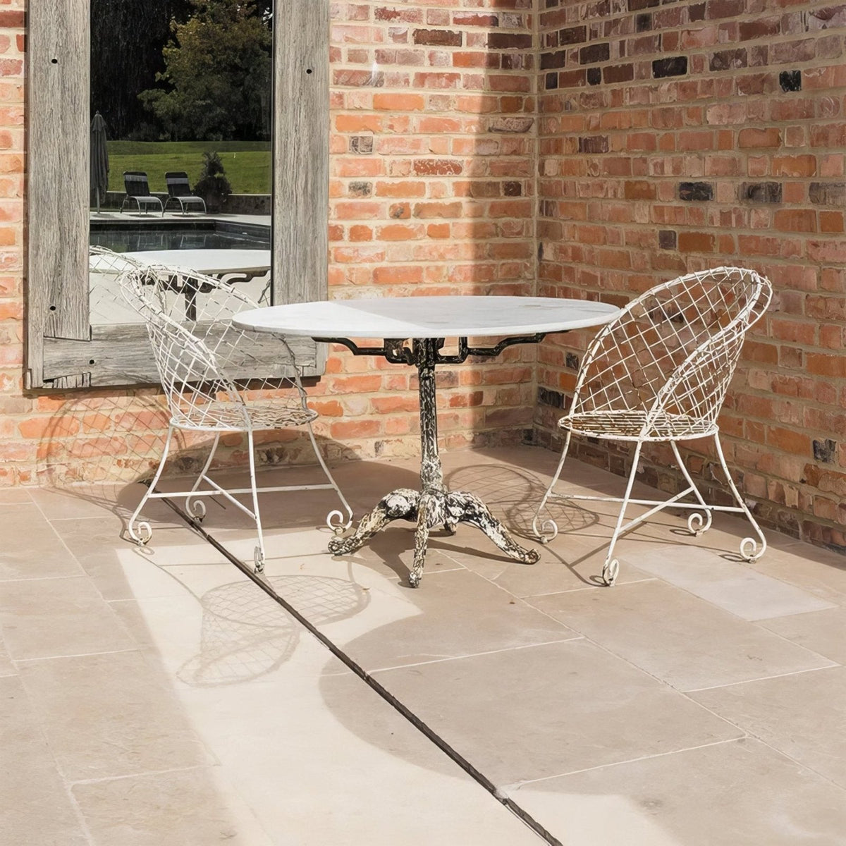 White wrought iron table on Buscot Limestone Tumbled & Etched floor tiles