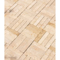 Beige and cream-colored buscot limestone tumbled and etched klinkers arranged in a rectangular herringbone pattern