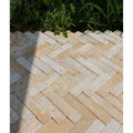 Beige and gray herringbone patterned buscot limestone tumbled and etched stone pavers for outdoor use