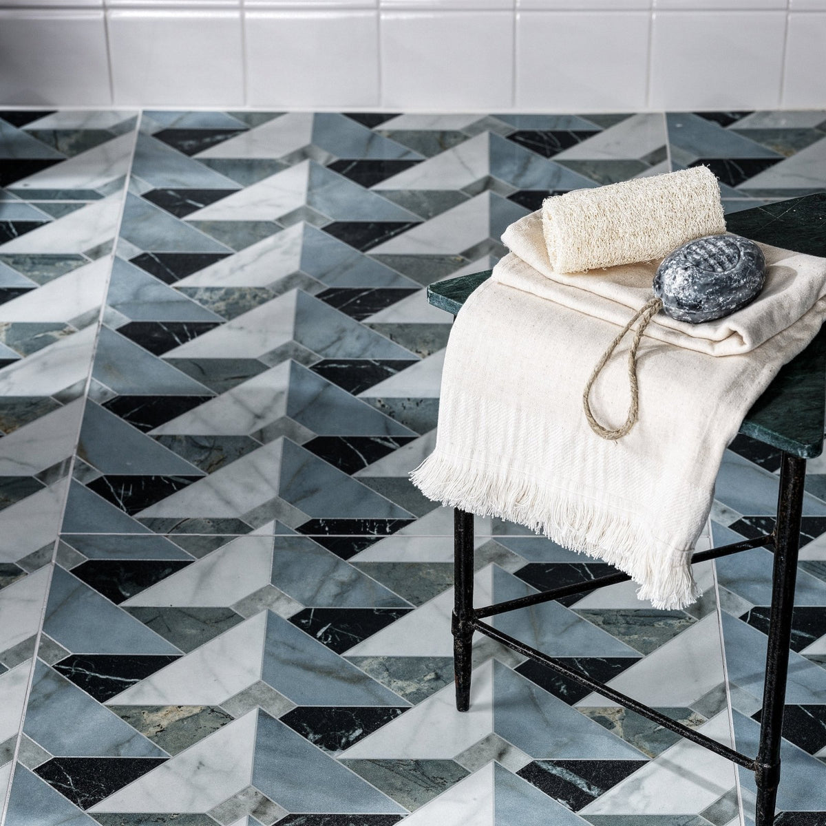 Geometric marble floor tiles in black white and gray arranged in a herringbone pattern from byzantine porcelain seraph sculpted collection