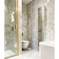 California Porcelain Beige beige marble-effect tiles in a bathroom with a gold-trimmed glass shower