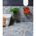 California Porcelain Ocean blue-grey marble-effect tiles with an orange soap dish and black fixtures