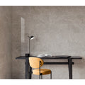 Capitol Grey Polished grey stone-effect tiles with a black desk lamp