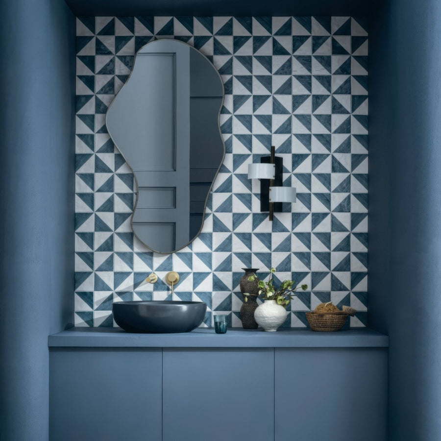 A sleek matte black ceramic vessel sink with minimalist design on a blue vanity in capri ocean hand painted tile setup