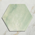 A hexagonal capri porcelain tile with a soft mottled green and white marble-like finish