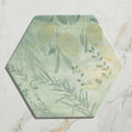 Capri porcelain hexagonal coaster with soft green and yellow botanical lemon design on textured stone surface