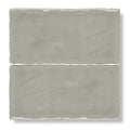 Two matte-finished gray ceramic carnival sella grey glazed rectangular tiles with slightly uneven edges